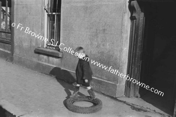 CHILD PLAYING WITH TYRE